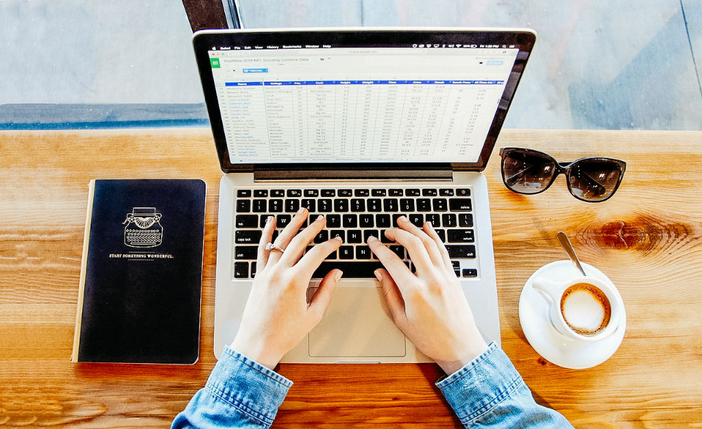Laptop mit Kaffee und Sonnenbrille